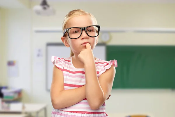 Mignonne petite fille en lunettes noires pensée — Photo