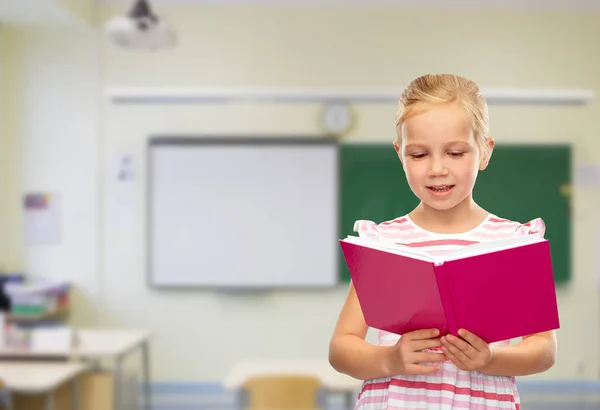 Leende liten flicka läsa bok — Stockfoto