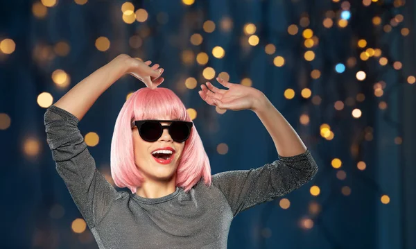 Ευτυχισμένη γυναίκα με ροζ περούκα και γυαλιά ηλίου χορεύει — Φωτογραφία Αρχείου