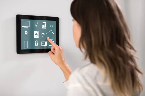 Женщина с помощью планшетного компьютера на умный дом — стоковое фото
