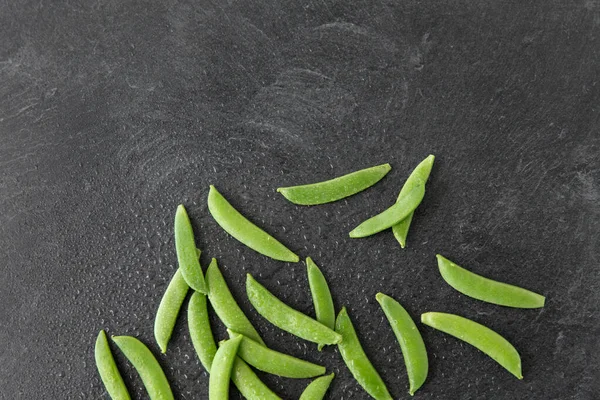 Petits pois sur fond de pierre d'ardoise humide — Photo