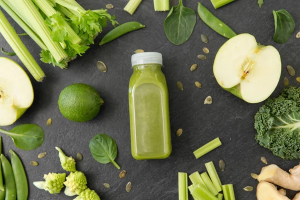 Primo piano di bottiglia con succo verde e verdure — Foto Stock