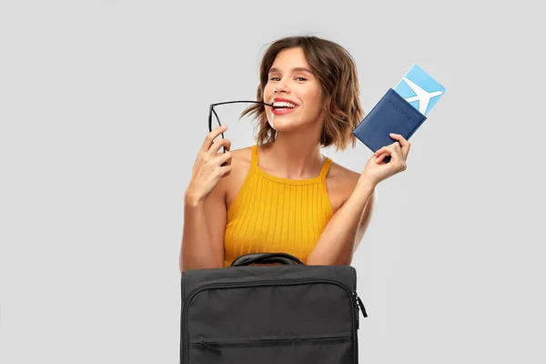 Heureuse jeune femme avec billet d'avion et sac de voyage — Photo