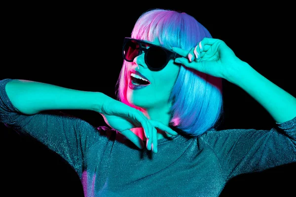 Mujer feliz en peluca rosa y gafas de sol bailando — Foto de Stock