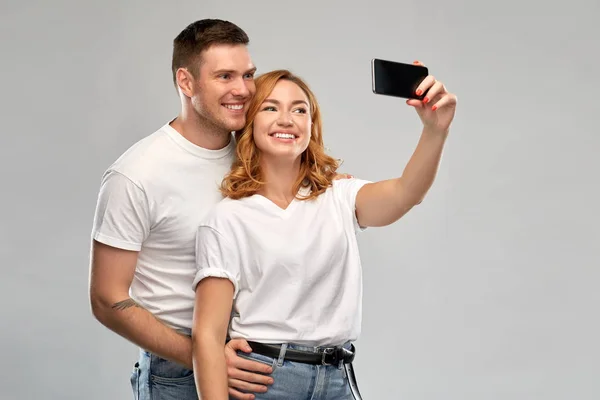 Felice coppia in bianco t-shirt prendendo selfie — Foto Stock