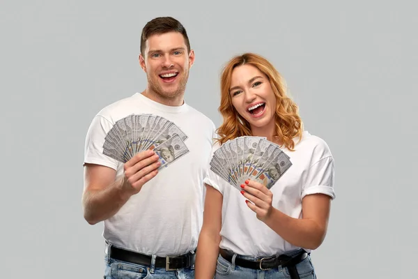 Šťastný pár v bílých tričkách s dolarovými penězi — Stock fotografie