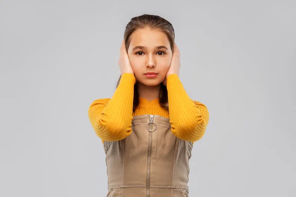 Улыбающаяся девочка-подросток закрывает уши руками — стоковое фото