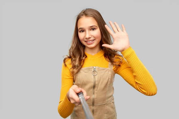 Glückliches Teenager-Mädchen macht Selfie und winkt — Stockfoto