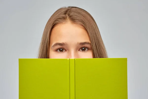 Adolescente estudante menina se escondendo sobre livro — Fotografia de Stock