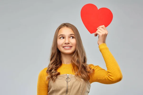 Smiling teenage girl with red heart — Stock Photo, Image