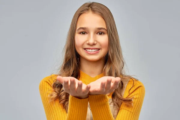 Tiener meisje houden iets op lege handen — Stockfoto