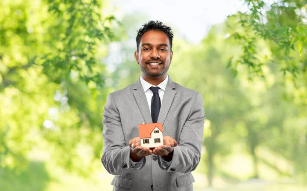 Man makelaar met huis model en map — Stockfoto