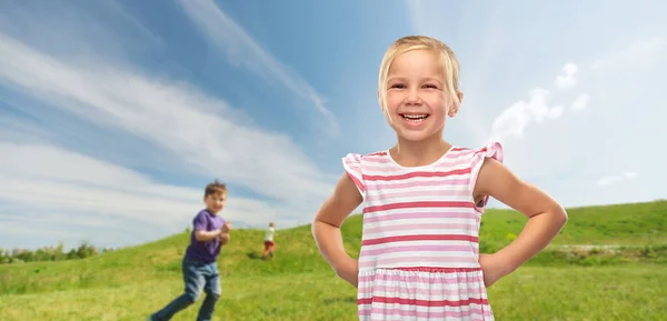 Smiling little girl in striped dress outdoors — ストック写真