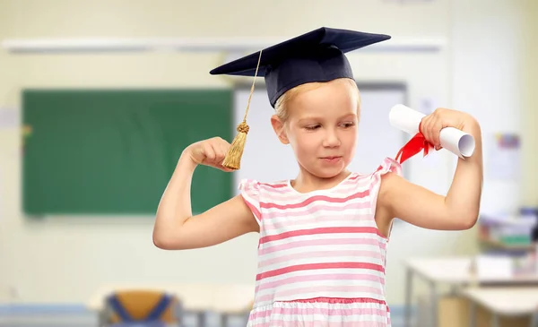 Little girl in mortarboard with diploma at school — Stock Photo, Image