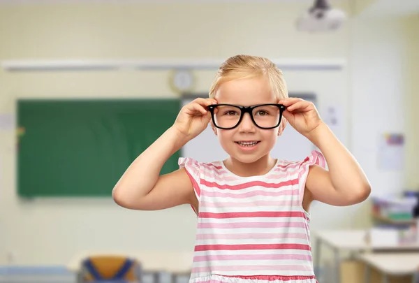 Sorrindo bonito menina em óculos pretos — Fotografia de Stock