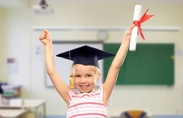 Happy little girl in mortarboard with diploma — Stock Photo, Image