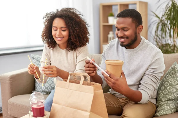 Happy couple with takeaway food and drinks at home — Stock Photo, Image