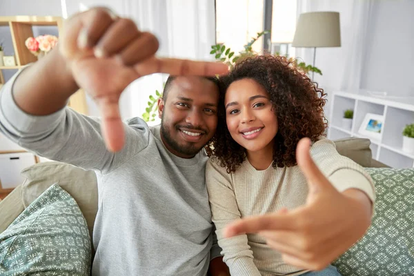 Feliz pareja haciendo selfie marco gesto en casa — Foto de Stock