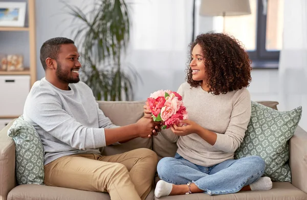 Couple heureux avec bouquet de fleurs à la maison — Photo