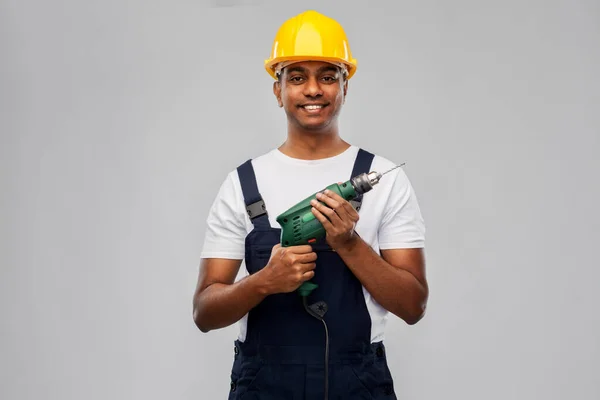 Šťastný indický stavitel v helmě s elektrickým vrtákem — Stock fotografie