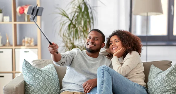 Couple prenant des photos par selfie stick à la maison — Photo