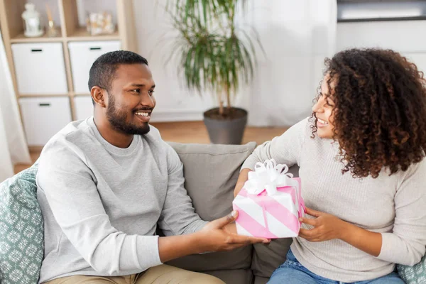 Feliz pareja con regalo en casa — Foto de Stock