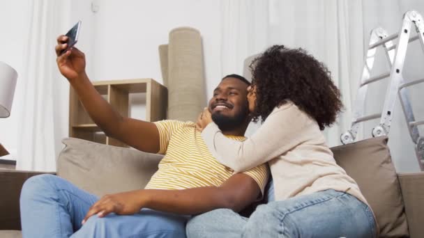 Feliz pareja mudándose a nuevo hogar y tomando selfie — Vídeos de Stock