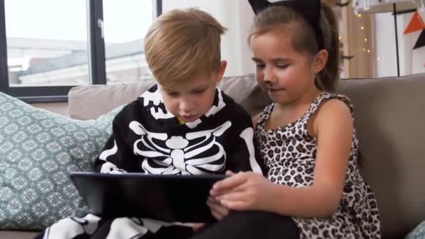 Barn i halloween kostymer med surfplatta dator hemma — Stockvideo