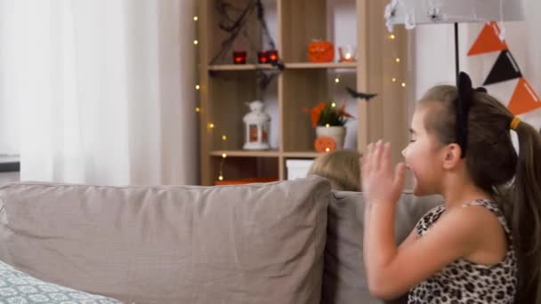 Дети в костюмах на Хэллоуин играют с игрушечным пауком — стоковое видео