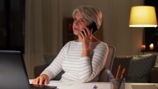 Anciana llamando en el teléfono inteligente en casa por la noche — Vídeo de stock