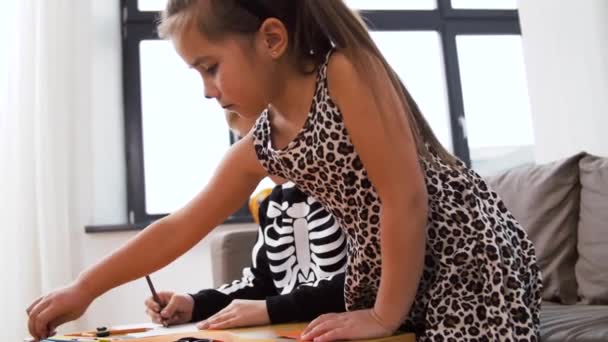Cadılar Bayramı kostümlü çocuklar evde el işi yapıyor. — Stok video