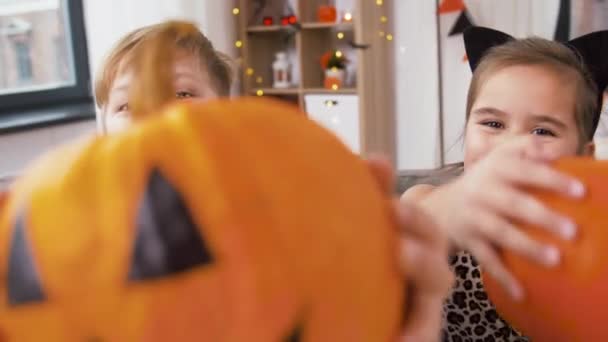Niños en trajes de Halloween con calabazas en casa — Vídeo de stock