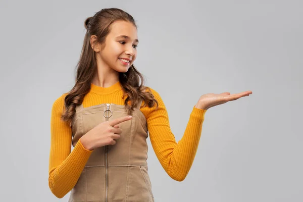 Glad tonåring flicka håller något på tom hand — Stockfoto