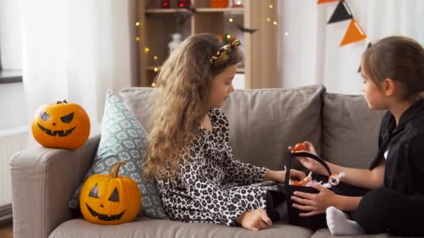 Mädchen in Halloween-Kostümen mit Bonbons zu Hause — Stockvideo