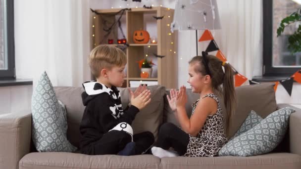 Kids in halloween costumes playing game at home — Stock Video