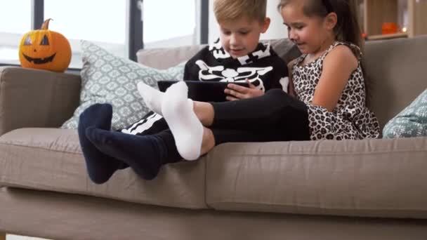 家里穿着带平板电脑的hallobetween服装的孩子 — 图库视频影像