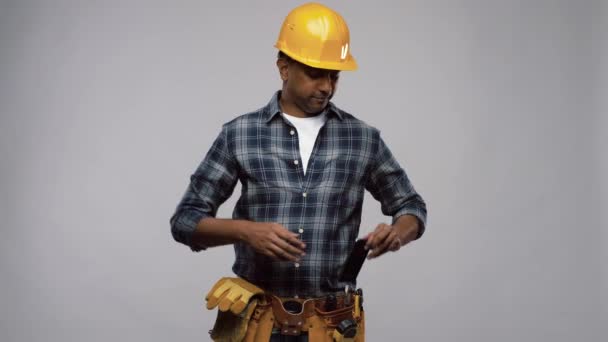 Indian builder in helmet calling on smartphone — Stock Video