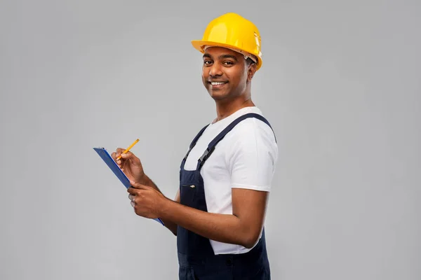 Construtor feliz no capacete com prancheta e lápis — Fotografia de Stock