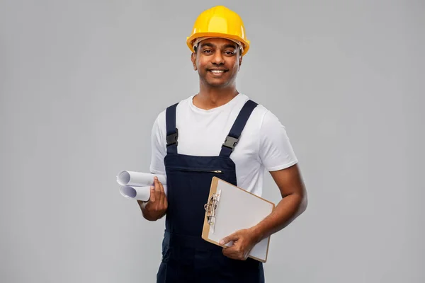 Construtor indiano feliz com planta e área de transferência — Fotografia de Stock
