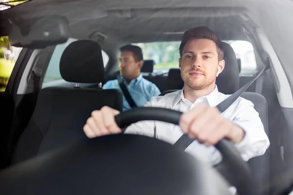 Motorista masculino com fones de ouvido sem fio carro de condução — Fotografia de Stock