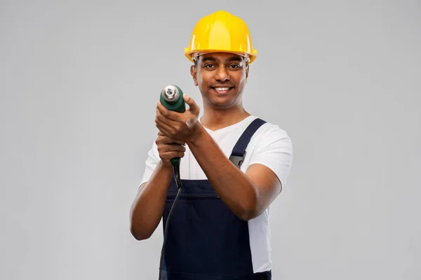 Construtor indiano feliz no capacete com broca elétrica — Fotografia de Stock