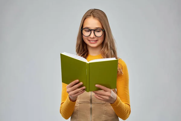 Gözlüklü genç kız kitap okuyor. — Stok fotoğraf