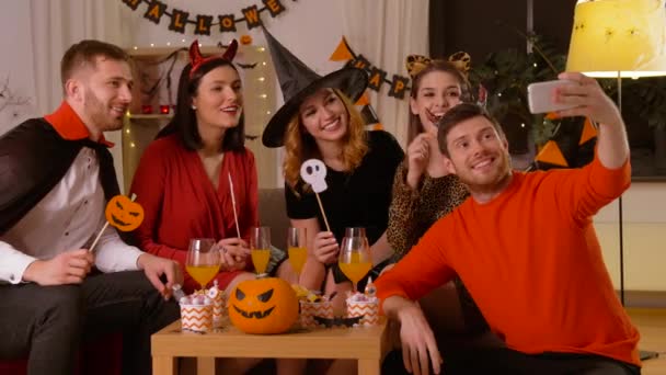 Счастливые друзья в костюмах на Хэллоуин делают селфи — стоковое видео