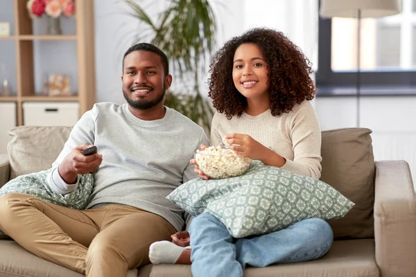 Africano pareja con palomitas de maíz viendo tv en casa — Foto de Stock