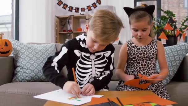 Ungar i halloween kostymer gör hantverk hemma — Stockvideo