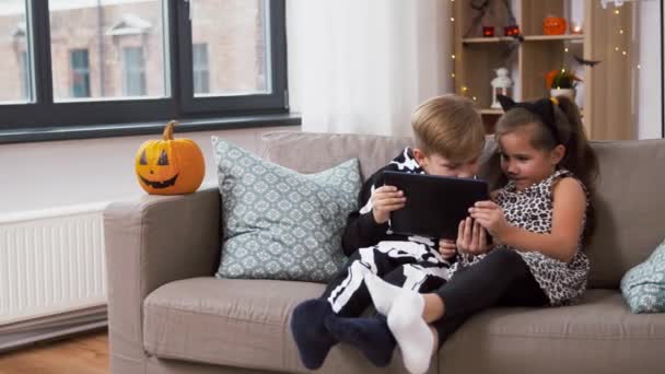 Barn i halloween kostymer med surfplatta dator hemma — Stockvideo