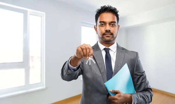 Uomo indiano agente immobiliare con chiavi di casa e cartella — Foto Stock