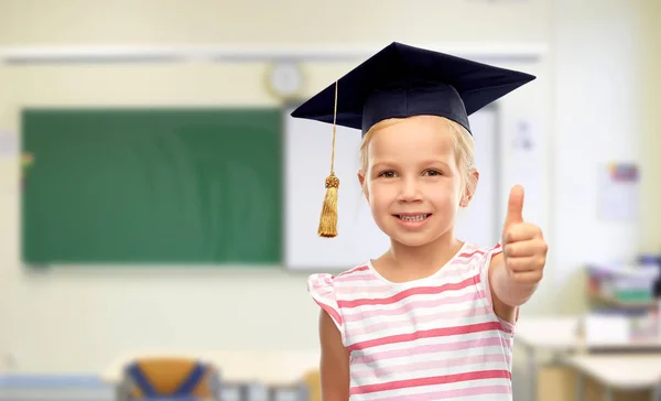 Mädchen in Mörtel zeigt in der Schule Daumen nach oben — Stockfoto