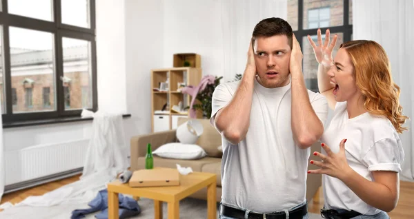 Pareja teniendo discusión sobre desordenado casa habitación — Foto de Stock