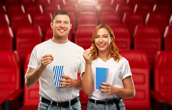 Happy couple eating popcorn at movie theatre — Stock Photo, Image